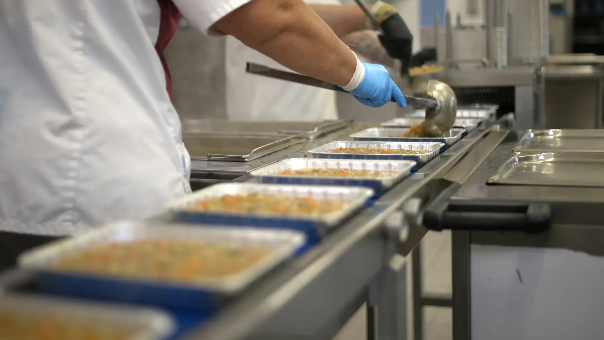 Gloved worker on a stainless steel food production line