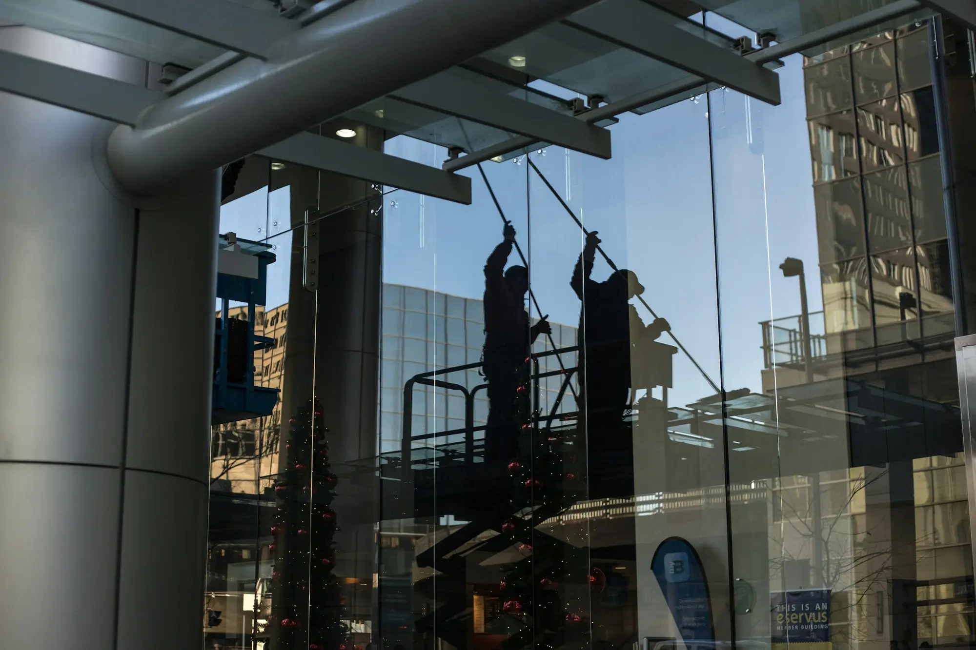 Window cleaners on a lift washing the glass facade of a commercial building